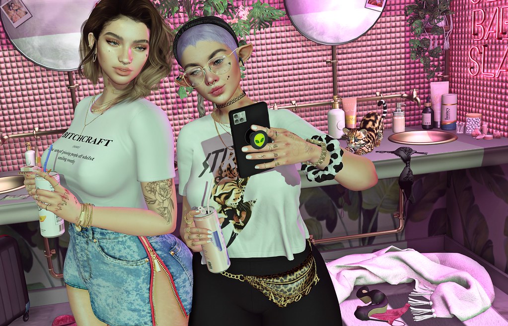 Two stylized female avatars take a mirror selfie in a neon pink tiled bathroom with a spotted kitten. — illustrating “Bio-Oil beyond stretch marks” on Florence and Mary