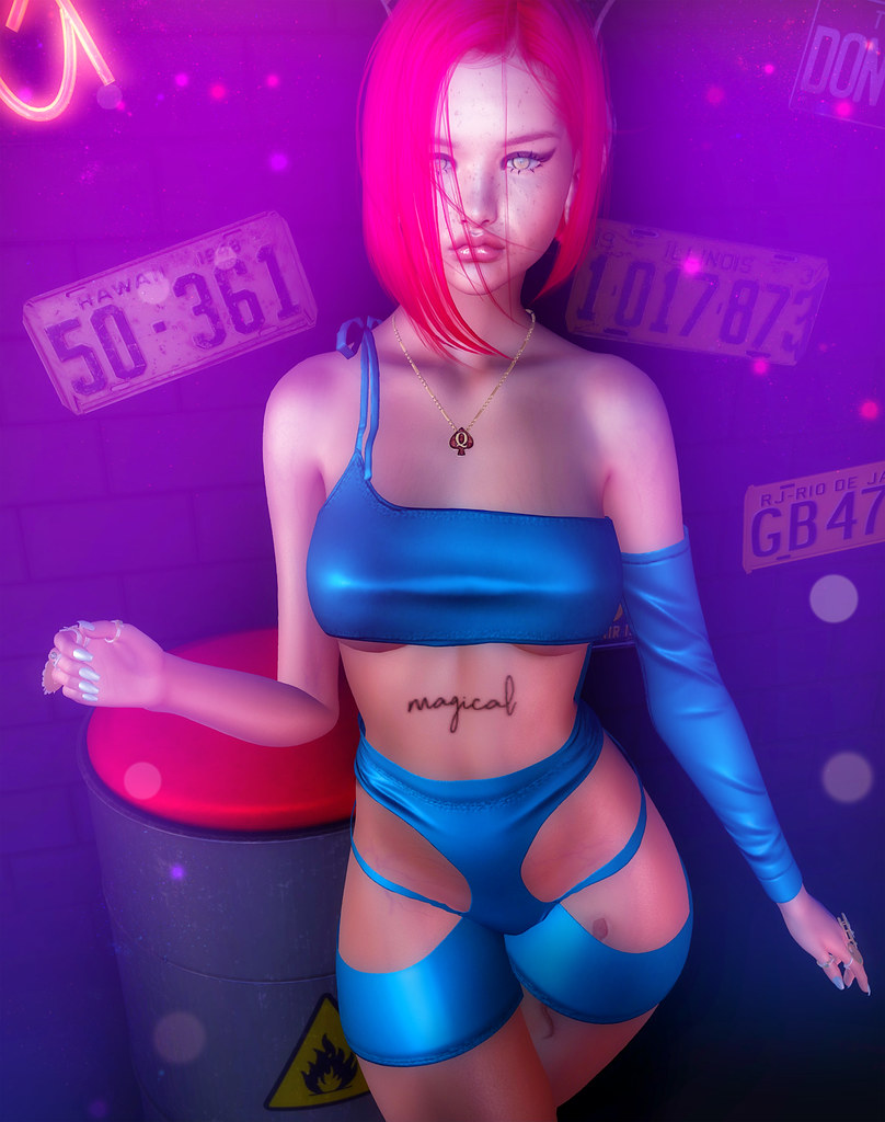 A pink-haired woman in a metallic blue cutout outfit poses against a purple-lit brick wall with license plates. — illustrating “Blogger Love” on Florence and Mary