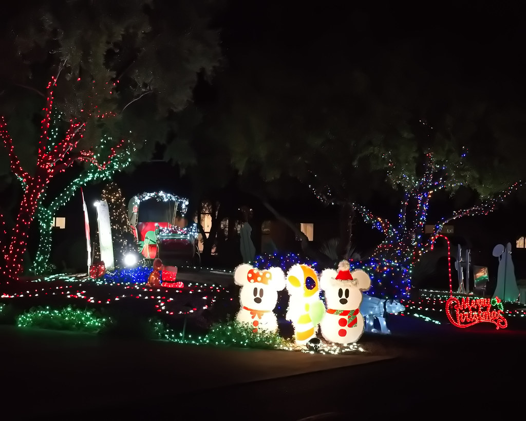 Three glowing mouse-shaped snowman figures stand on a lawn decorated with red, green, and blue Christmas lights. — illustrating “Christmas Cleaning with Dyson” on Florence and Mary