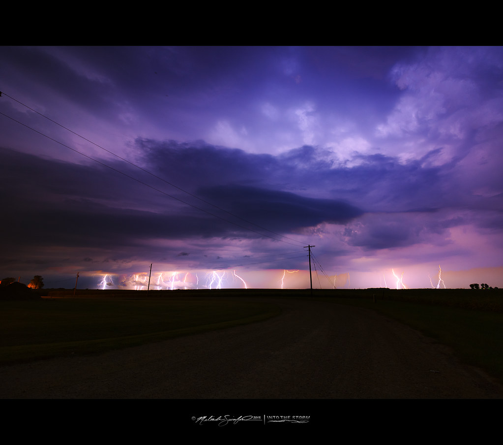 Multiple bright lightning bolts illuminate a dark rural horizon under a dramatic deep purple stormy night sky. — illustrating “Happy New Year” on Florence and Mary