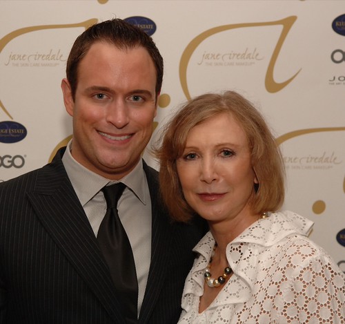 A man in a pinstripe suit and a woman in a ruffled white blouse pose before a jane iredale backdrop. — illustrating “Lush Cosmetics | Mask of Magnaminty” on Florence and Mary