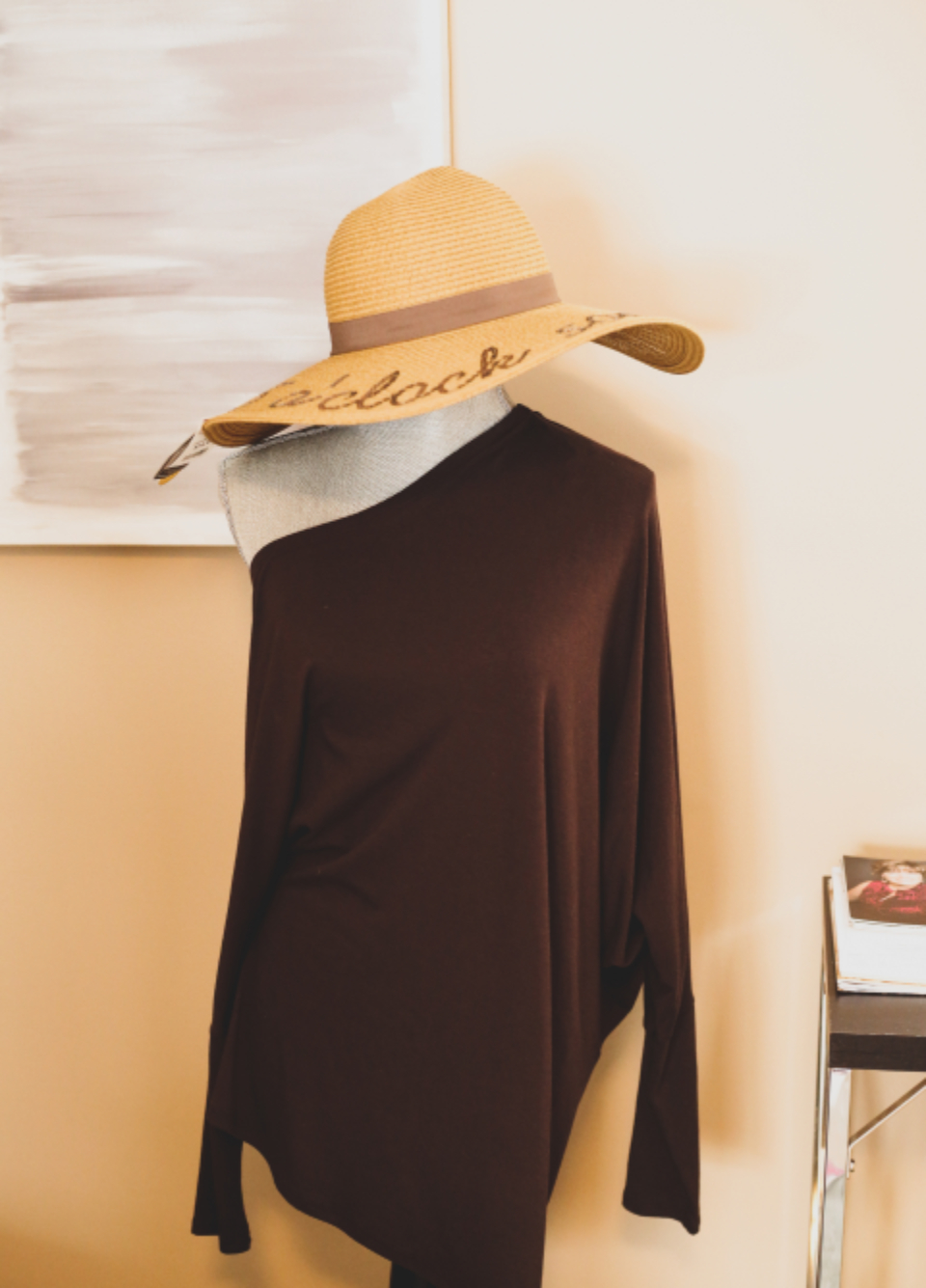 Wide-brimmed straw hat on a mannequin in a dark brown off-shoulder top beside abstract art. — illustrating “OOTD // I do like to be beside the seaside” on Florence and Mary