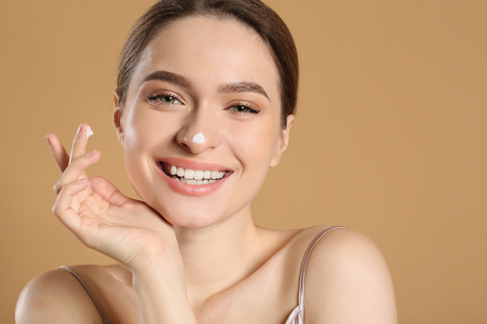 Smiling woman with small dabs of white skincare cream on her nose and index finger. — illustrating “Review // Heaven Skincare Wipes” on Florence and Mary