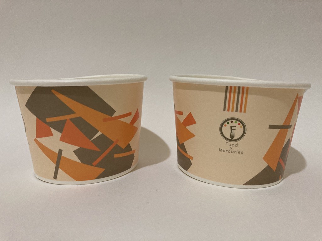 Two paper tubs with orange-brown geometric shapes and Food X Mercuries logo on plain background. — illustrating “Serendipty // Topshop Tea Dress and Primark Sandles” on Florence and Mary