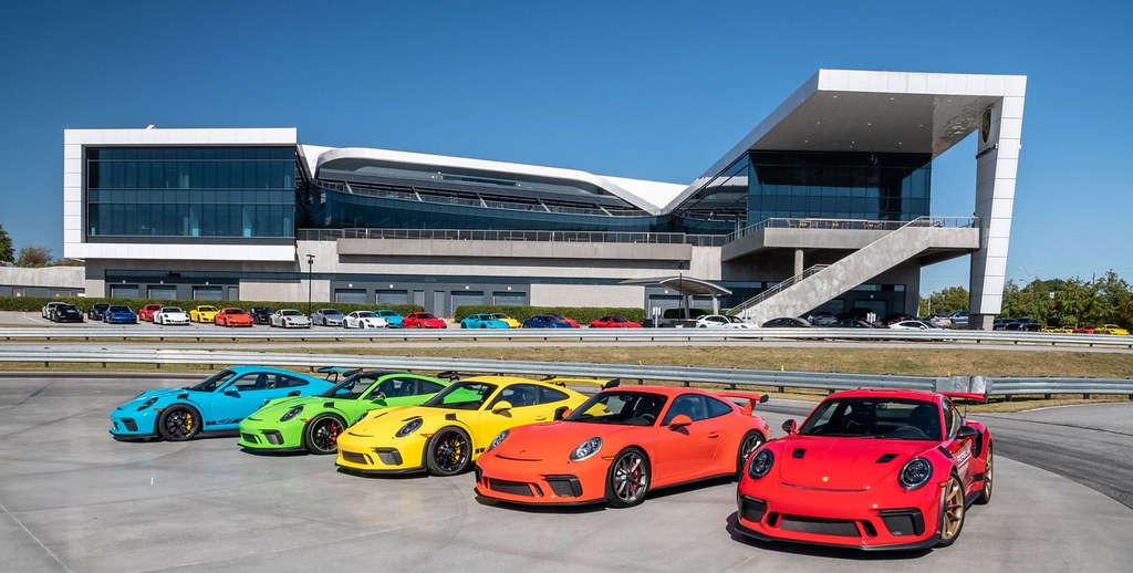 Five vibrant sports cars in blue, green, yellow, orange, and red parked before a modern glass building. — illustrating “The Book Lover Survey” on Florence and Mary