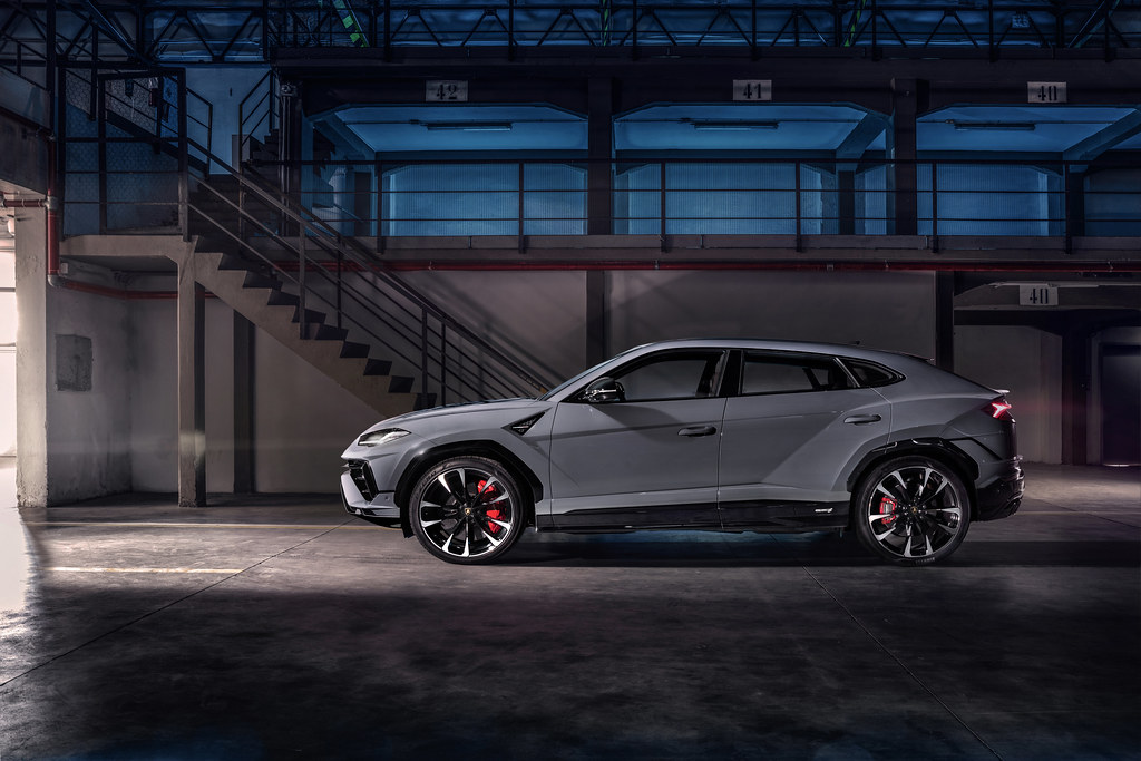 Sleek grey luxury SUV in a dark industrial garage with blue-lit bays and red brake calipers. — illustrating “The Comforter Bubble Bar from Lush” on Florence and Mary