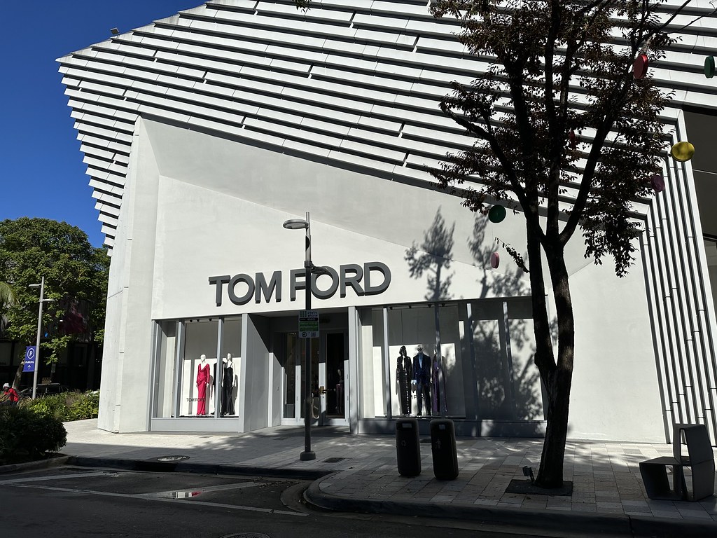 Modern white building with slanted slatted facade showing Tom Ford name and mannequins in windows. — illustrating “Tom Ford on Rodeo Drive” on Florence and Mary