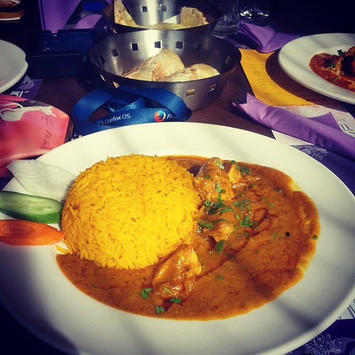 A white plate of yellow saffron rice and creamy chicken curry sits beside naan baskets. — illustrating “Week 47 // Bruno, Burgers and Butlers” on Florence and Mary