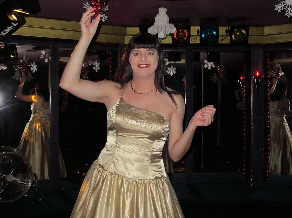 A person in a shimmering gold gown and dark wig smiles amid hanging snowflakes and ornaments. — illustrating “Week 48 // The Festive Season has arrived” on Florence and Mary