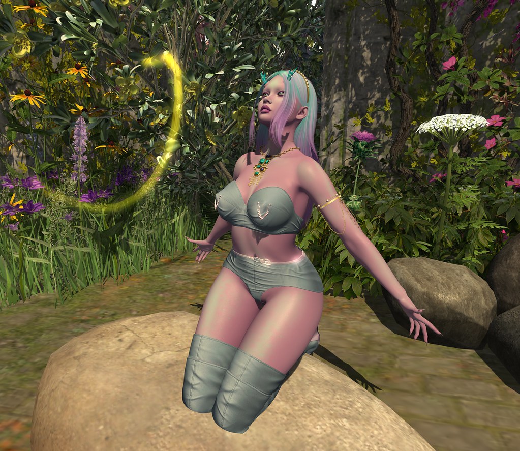 A pink-skinned figure with multicolored hair kneels on a rock in a flower-filled glowing garden. — illustrating “Wet n Wild Comfort Zone Palette Review” on Florence and Mary